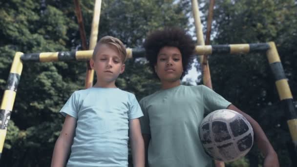 Chicos molestos mirando la cámara en el campo de fútbol, falta de amigos, problemas de intimidación — Vídeos de Stock