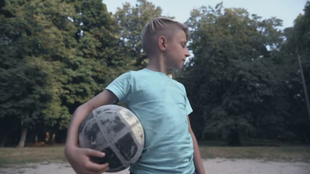Μοναχικός αναστατωμένος αγόρι κρατώντας το ποδόσφαιρο στο γήπεδο, έλλειψη φίλων, πρόβλημα εκφοβισμού — Αρχείο Βίντεο