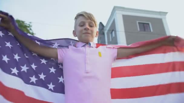 Menino americano acenando com a bandeira dos EUA, celebrando o dia da independência, 4 de julho — Vídeo de Stock