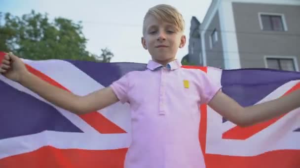 Jongen zwaaiend met Britse vlag, viert nationale feestdag buiten, patriottisme — Stockvideo