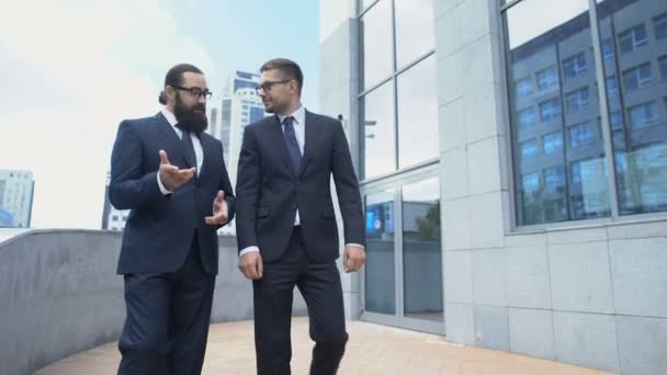 Deux hommes d'affaires marchant dans la rue et discutant activement des conditions contractuelles — Video