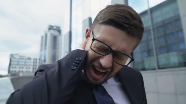 Man in suit suffering sharp neck pain outdoor, spinal diseases symptom, cramp — Stock Video
