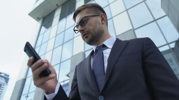 Frustrerad man i kostym läser dåliga nyheter på telefon, konkurs, konkurs — Stockvideo