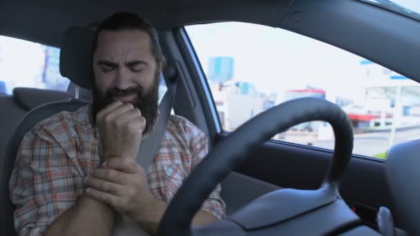 Homme barbu massant le poignet en conduisant une voiture, main blessée, inflammation articulaire — Video