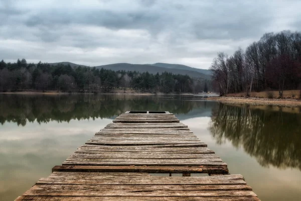 Gölü akşam arka plan tepelerde ile rıhtımda. Yeşil su mavi bulutlu gökyüzü ile ormanda yansıman. Orman gölette. Küçük göl inrecreational alanı (Slovakya - Duchonka)