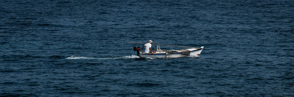 Old Wooden Motorboat With Single Man On Mediterranean Sea