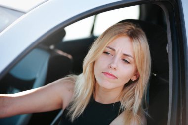 - Arabadaki kız trafik sıkışıklığında. Şoför konsepti. Şehirde araba süren genç bir kadın. Arabadaki güzel bir kadının portresi.
