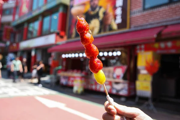 Hand holding a traditional Chinese snack, candied strawberries fruit skewers — Stock Photo, Image