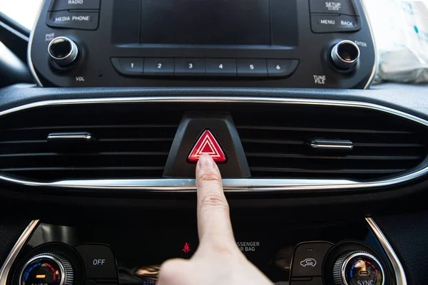 Dedo pressionando um botão luzes de advertência de perigo em um carro coreano de luxo moderno — Fotografia de Stock