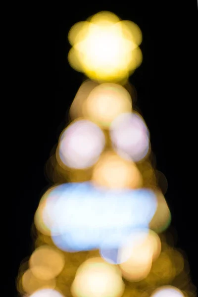 Nem fókuszált karácsonyfa sárga világítással. Bokeh fény karácsonyfa — Stock Fotó