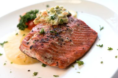 Beyaz tabakta servis edilen kerevizli karamelli ananas somonu fileto.