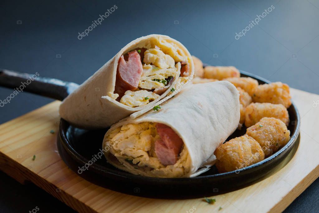 Burrito de desayuno con salchichas y huevo revuelto y hachís marrón en