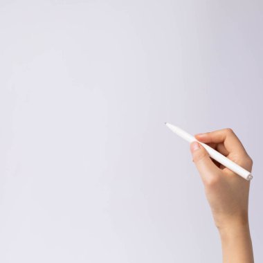 Close up image of hand holding a white pen on a white background
