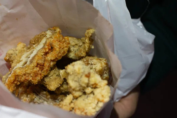 Pollo frito de estilo taiwanés grande cortado en tiras largas en una bolsa de papel . Imagen De Stock