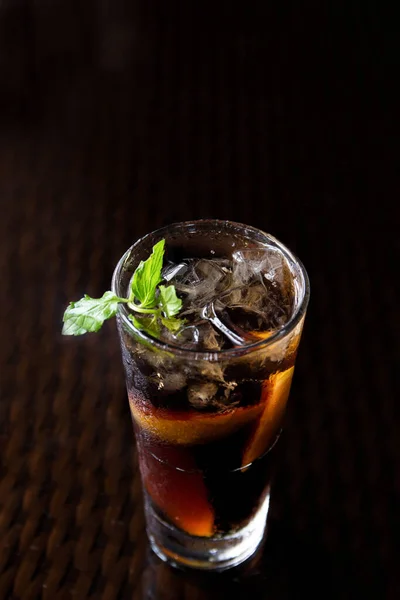 Long Island cocktail drink with mint leaf on a black background.Long Island cocktail drink with mint leaf on a black background.