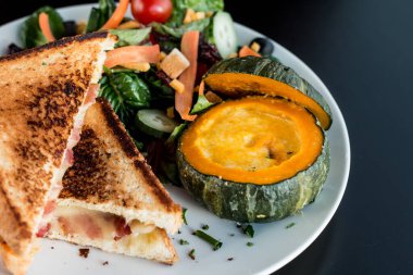 Peynirli pastırmalı tost ekmeği ve balkabağı çorbasının üst görüntüsü..