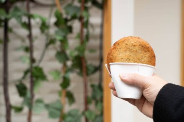 Kore usulü yağda kızartılmış krep, Hotteok, elinde tatlı dolgu malzemeleriyle. Popüler Kore sokak yemekleri.