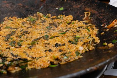 Kore usulü baharatlı pilav, deniz yosunu ve sebzeli büyük bir tavada pişmiş..