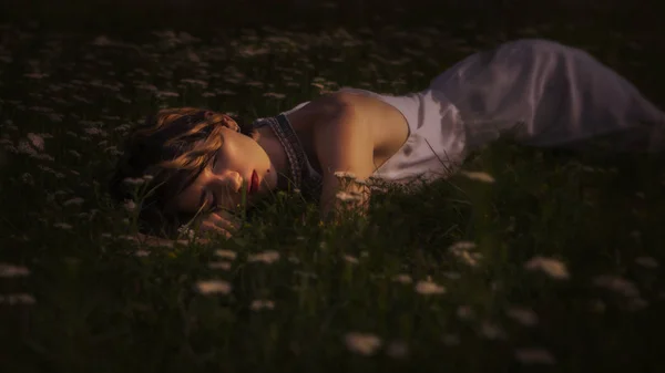 Piękna Brunetka kobieta spanie w trawy i kwiaty w — Zdjęcie stockowe