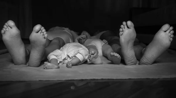 Ευτυχισμένη οικογένεια βάζοντας στο πάτωμα, τους feets σε εστίαση. Μητέρα, — Φωτογραφία Αρχείου