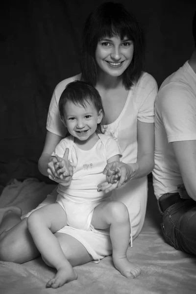 Pequeña linda niña de 2 años acostada en los brazos de las madres sonriendo. Neutral — Foto de Stock