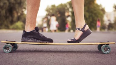 Adam ayakları roa üzerinde bir longboard üzerinde duran kadın, öpüşme