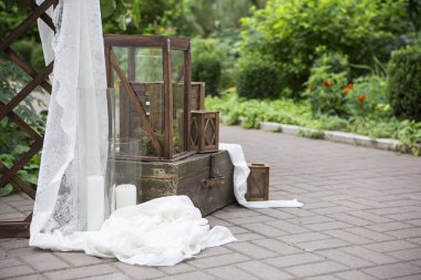 Mumlar ve kumaş bahçesinde bir w üzerinde süslenmiş ahşap vazolar