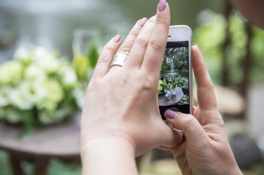 Eustoma gül ve gl onun telefon buket üzerinde fotoğraf çekimi kadın