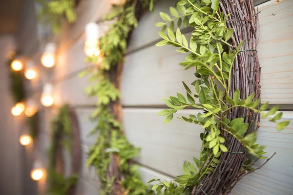 Wreath natural garland decorated with bulb lights on a wooden ba — Stock Photo, Image