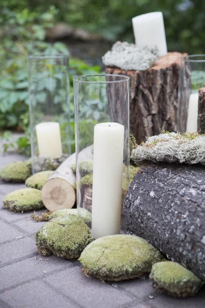 Stronken versierd met mos en kaarsen in de tuin, op een bruiloft c — Stockfoto