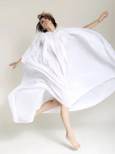 ホワイト スタジオのロングドレスでスリム フィット白人ブルネットの女性. — ストック写真