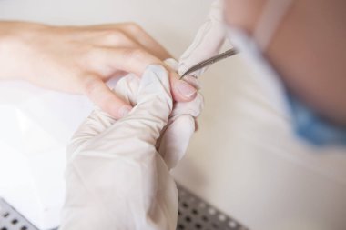 Lastik eldiven yapmak ana tırnak manikür (bakım kütikül) bir w üzerinde