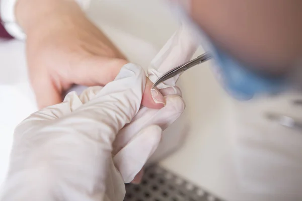 El maestro de uñas en guantes de goma hace manicura (cutícula de cuidado) en una w —  Fotos de Stock