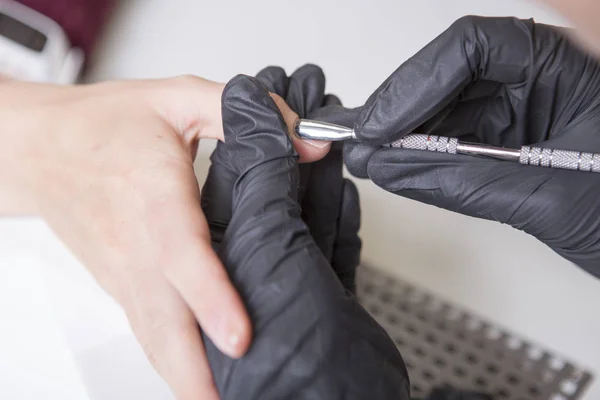 Maestro de uñas en guantes de goma aplicar gel laca laca en una mujer —  Fotos de Stock