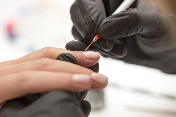 Maestro de uñas en guantes de goma aplicar gel laca laca en una mujer —  Fotos de Stock