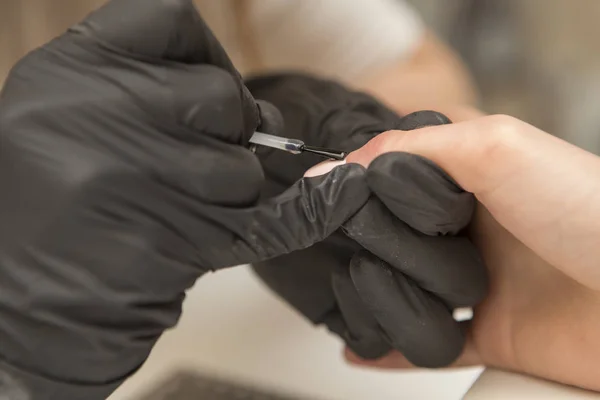 Καρφί master στα λαστιχένια γάντια εφαρμογή gel βερνίκι shellac σε μια γυναίκα — Φωτογραφία Αρχείου