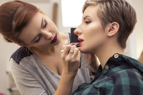 Prachtige brunette vrouw make-up artiest toepassen make up een beroe — Stockfoto