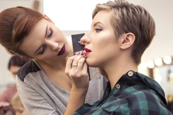 Prachtige brunette vrouw make-up artiest toepassen make up een beroe — Stockfoto