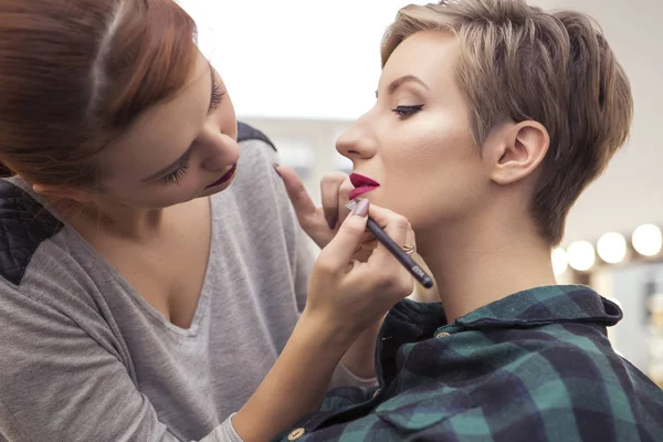 Prachtige brunette vrouw make-up artiest toepassen make up een beroe — Stockfoto