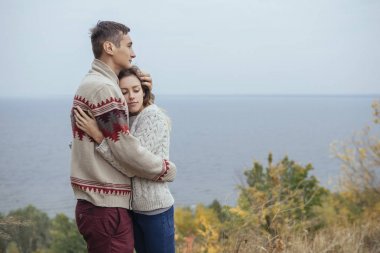 Eac sarılma deniz kenarında bir uçurumun üzerinde mutlu düşünceli çift duran