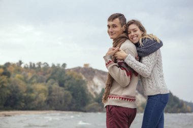 Mutlu düşünceli çift ayakta deniz huggin yakınındaki bir rock Beach