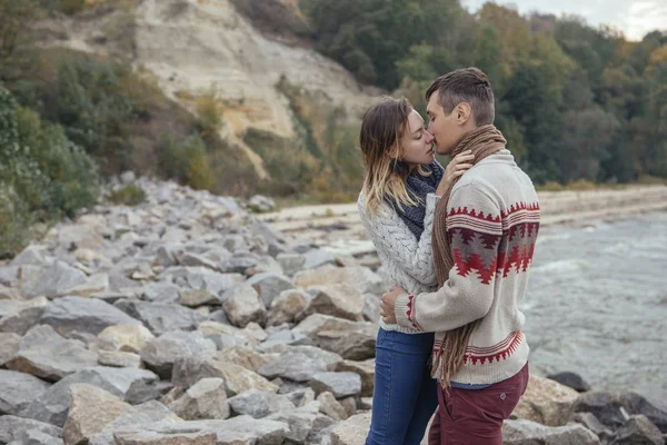 Šťastný pár promyšlených stojící na rockové pláž u moře huggin — Stock fotografie