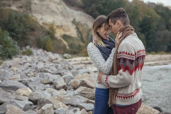Glückliches nachdenkliches Paar, das an einem Felsstrand in der Nähe des Meeres steht — Stockfoto