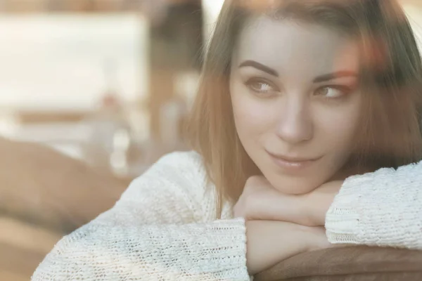 Beautiful young teenage caucasian woman in sweater sitting at th — Stock Photo, Image