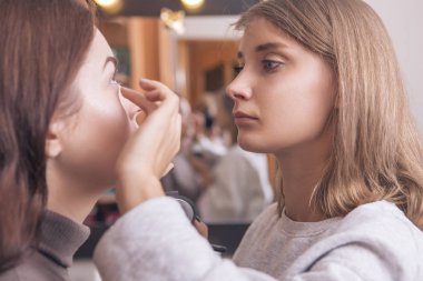 Profesyonel sanatçı makyaj uygulamak maskara genç bir beyaz w