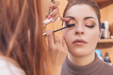Profesyonel sanatçı makyaj uygulamak maskara genç bir beyaz w