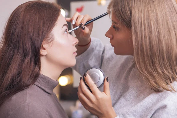 Professionell makeup artist applicera mascara på en unga kaukasiska w — Stockfoto