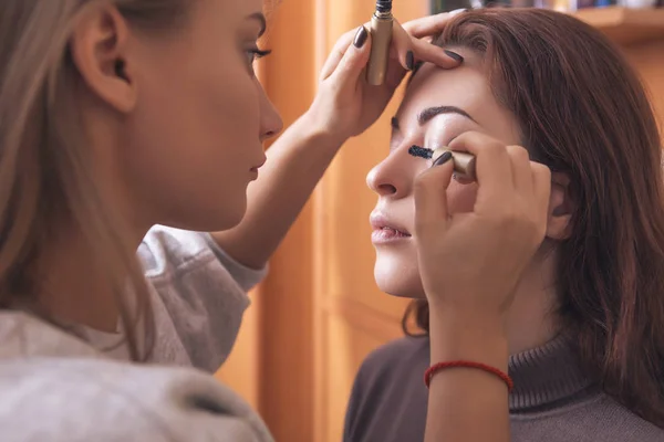 Professional make up artist apply mascara to a young caucasian w — Stock Photo, Image