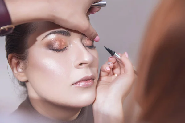 Profesionální make-up umělce použít řasenku na mladý bělošský w — Stock fotografie
