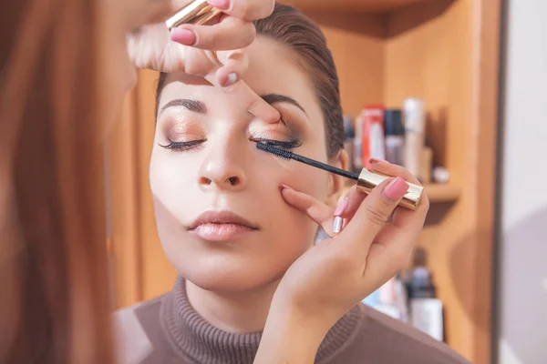 Professionell makeup artist applicera mascara på en unga kaukasiska w — Stockfoto